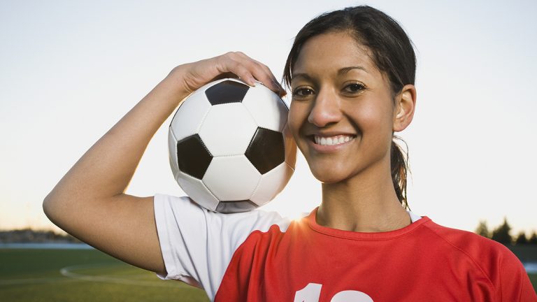 Girl holding up a soccer ball
