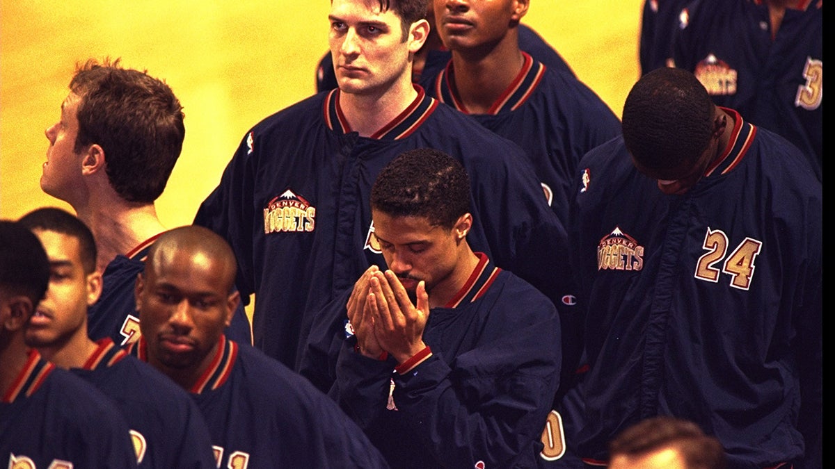 Point guard Mahmoud Abdul Rauf of the Denver Nuggets prays during the singing of the national anthem during a 1996 Nuggets game