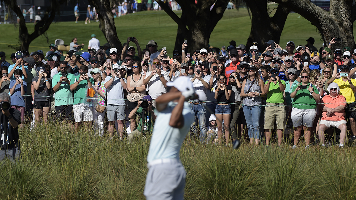 Fans take pictures as Tiger Woods hits his tee shot at hole No. 18 during the third round of the Arnold Palmer Invitational