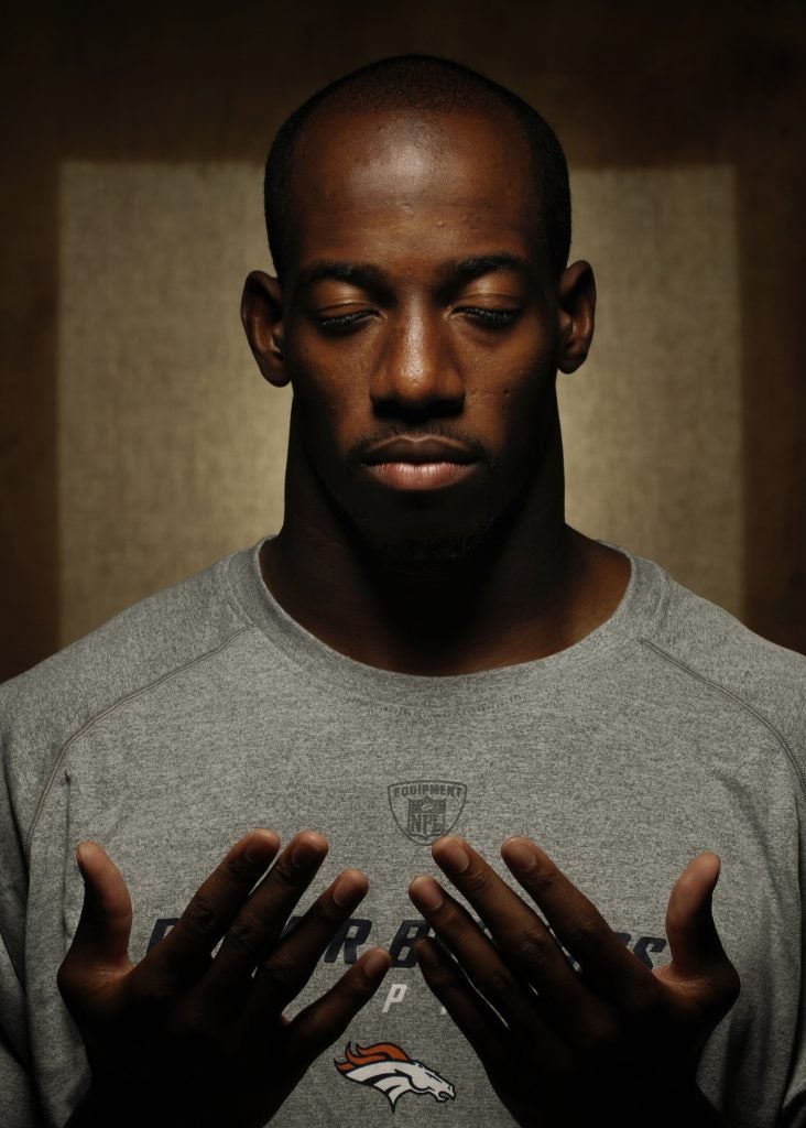 Former NFL player Hamza Abdullah holds up his hands and looks at his palms