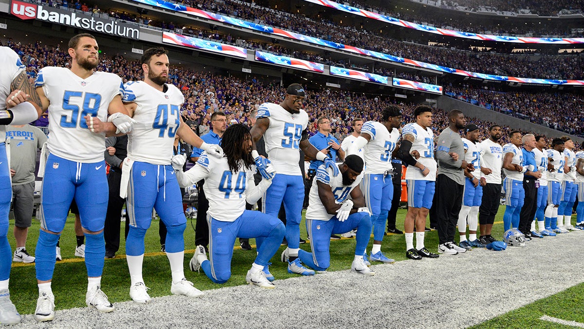 Landover, United States. 25th Oct, 2020. Members of the Washington Football  Team stand, kneel, and hold their first up during the national anthem  before an NFL football game against the Dallas Cowboys