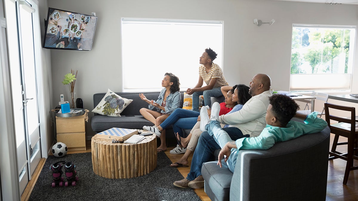 Family of six watching t.v. together 