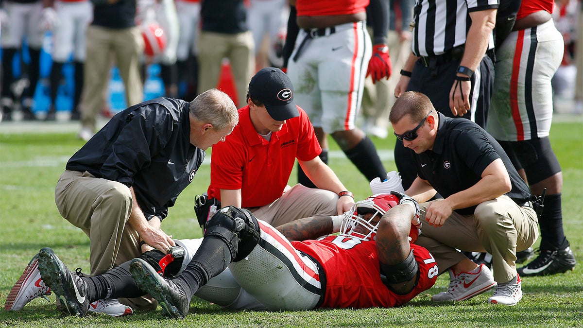 Injured defensive lineman from Georgia being attended by staff