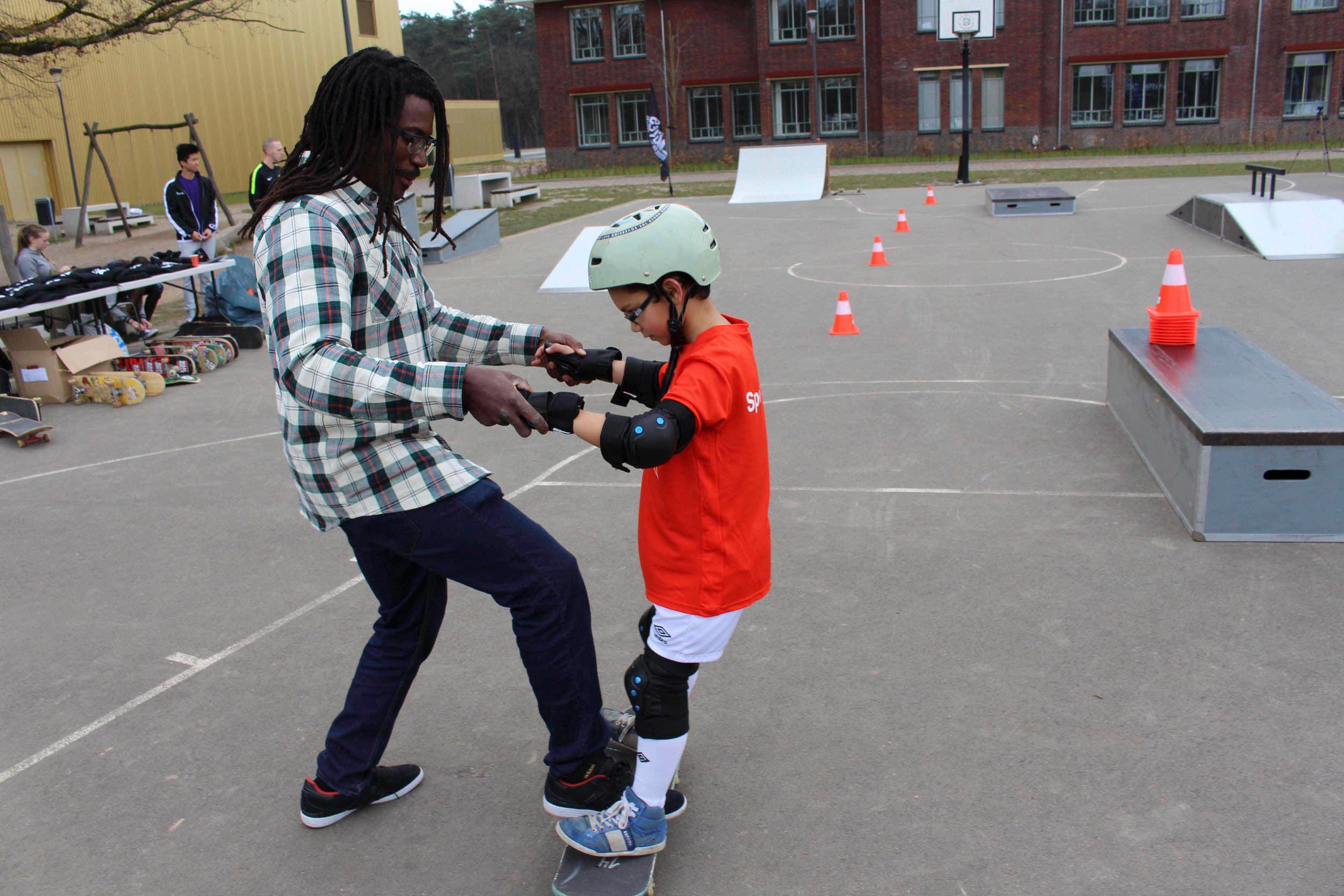 Neftalie Williams helps young skateboarder