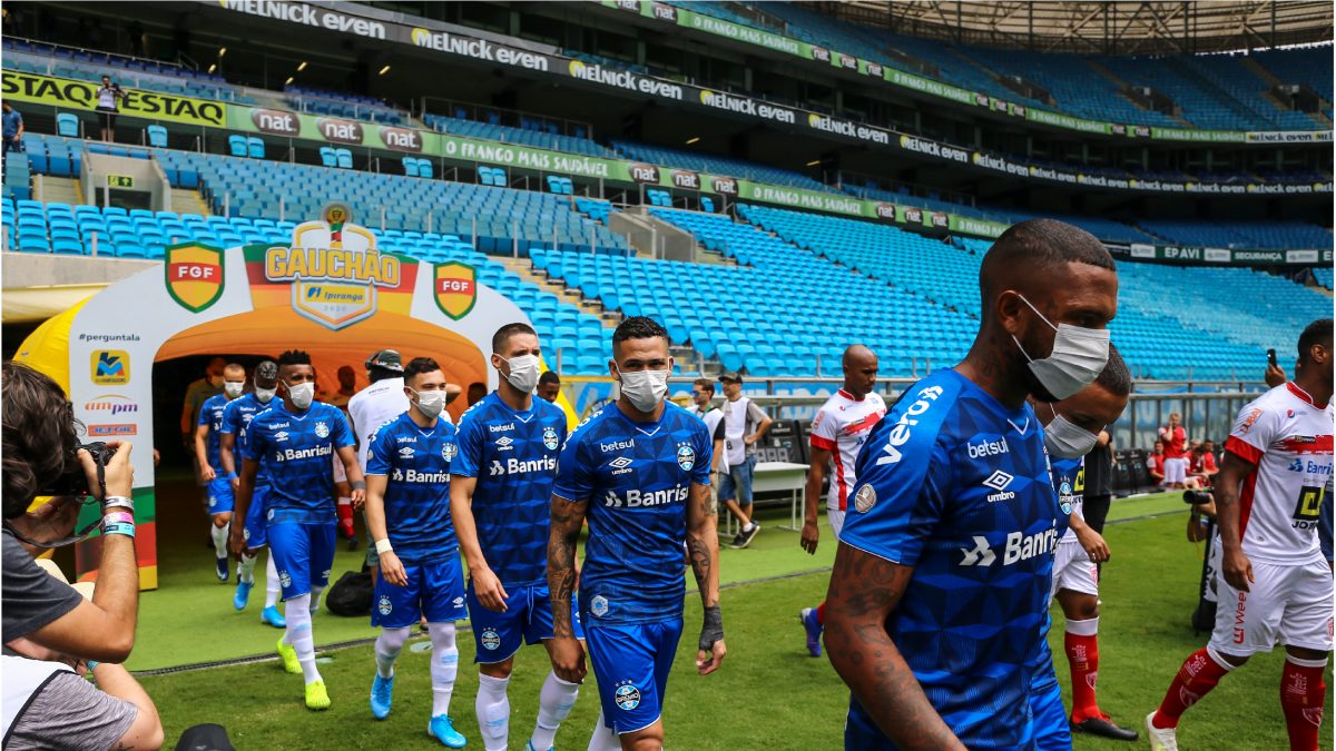 PORTO ALEGRE, BRAZIL - MARCH 15: Players of Gremio enter the field wearing masks before the match between Gremio and Sao Luiz as part of the Rio Grande do Sul State Championship 2020, to be played behind closed doors. (Photo by Lucas Uebel/Getty Images)