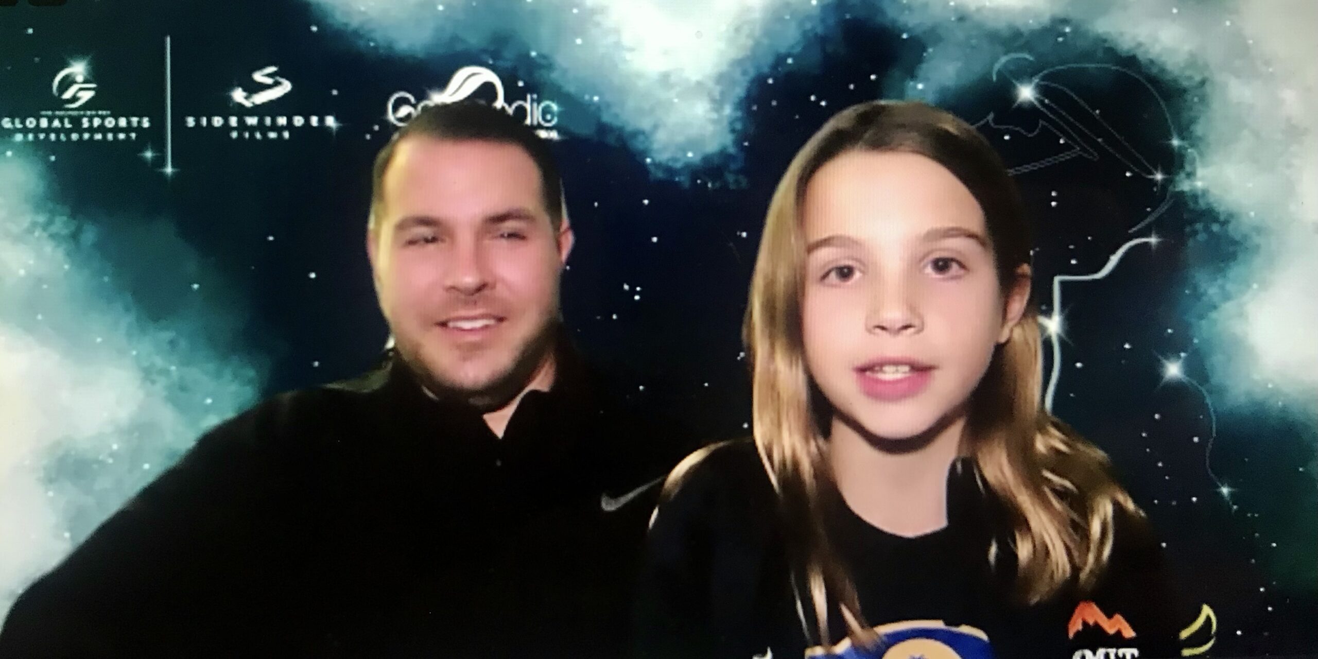 A Zoom screenshot of Cami Wood with a family member. They have an outer space themed virtual background.